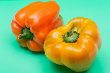 Fresh Ripe Organic Bell Peppers, a cultivar group of the species Capsicum annuum, isolated on green background.