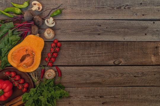 Vegetables on vintage wooden background. Autumn harvest. Organic food background. Farmers vegetable market. Seasonal fall vegetables. Rural still life from above with free text space. Toned image.