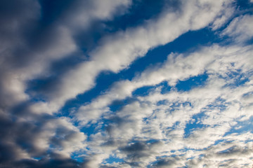 Fototapeta premium Waves of white clouds against the blue sky