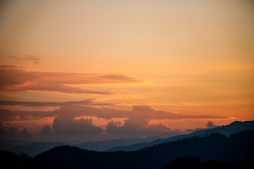 sunset in the austrian alps with silhouette of colorful clouds and mountains in the austrian alps in styria