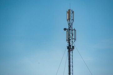 4G and 5G cell site. Telecommunications. City tower cells for mobile communications. Base transceiver station and wireless communication antenna transmitter on antennas against blue sky.