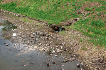 Rubbish pollution with plastic and other packaging stuffs on the bank of the river Kharkiv near bridge in Kharkiv