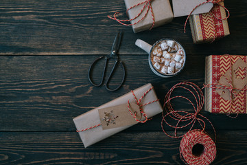 Celebratory Christmas and New Year's holidays background. Gift boxes wrapped craft paper with twine, decorations and spice on the wooden rustic background. Copy space for you text.