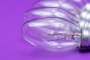 Clear Incandescent Night Light Bulbs with candelabra base on purple background.