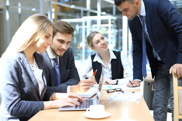 Startup business team on meeting in modern bright office interior and working on laptop.