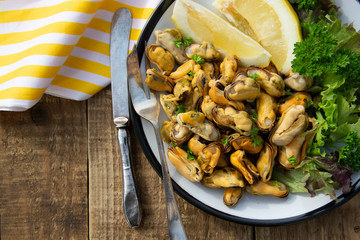 Peeled mussels with fresh lemom. Healthy seafood, natural sunlight, wooden rustic table.