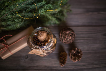 Christmas gift with homemade gingerbread cookies, nuts and chocolates. Glass jar, fir branches, Christmas spices and decor. Winter holidays, New Year or Christmas concept. Top view with copy space.
