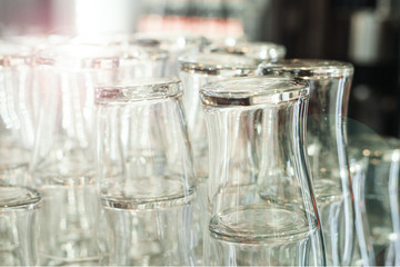 Empty clean bar beer glasses on the bar counter. A lot of shiny transparent beer mugs at the sink. Bar accessories. Glasses for drinks