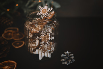 Christmas gift with homemade gingerbread cookies, nuts and chocolates. Glass jar, fir branches, Christmas spices and decor. Winter holidays, New Year or Christmas concept. Top view with copy space.