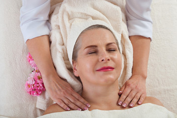 face massage in spa macro. Attractive woman with close eyes taking skin care. Massage face selective focus.