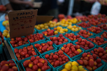 In paper containers packed tomatoes cherry ready for sale in a vegetable farmer's market. Tomatoe grapes on display at the market. Eco product. Ecology and preservation of the environment concept.