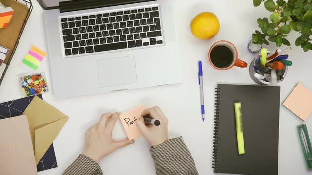 Top down view of man sticking notes with party 21 p.m.