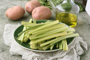 borage potatoes olive oil and other raw vegetables, on a marbled green background