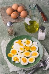 salad of boiled eggs, in green porcelain dish, on green marbling background