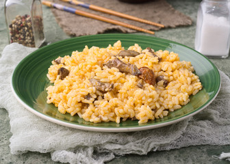 Homemade rice stew on plate and green stage
