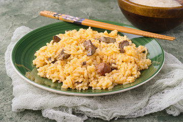 Homemade rice stew on plate and green stage
