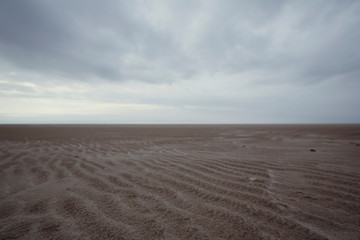 Fototapeta na wymiar Ground view of sandy beach on cloudy day