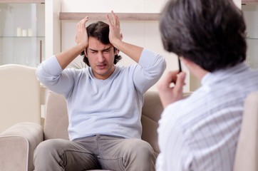 Young male patient discussing with psychologist personal problem