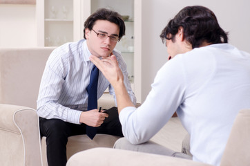 Young male patient discussing with psychologist personal problem