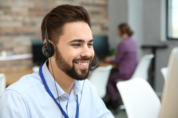 Technical support operator working with headset in office