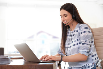 Young woman using video chat on laptop in home office