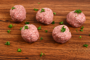 closeup raw meatballs with parsley