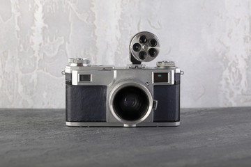 Old rangefinder film camera on grey cement background. - obrazy, fototapety, plakaty