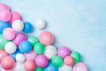 Heap of colorful balloons on blue table top view. Birthday or party background. Flat lay style. Copy space for text.