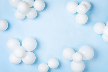 Pastel blue table with white balloons top view. Party or birthday background. Flat lay style.