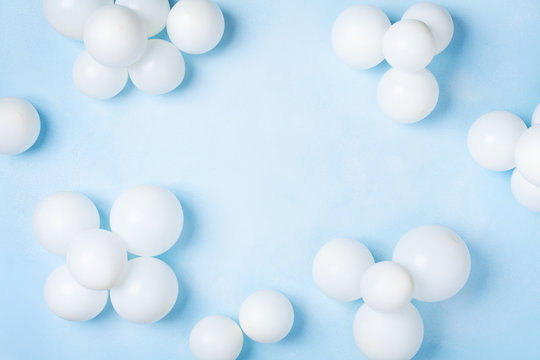 Pastel blue table with white balloons top view. Party or birthday background. Flat lay style. © juliasudnitskaya