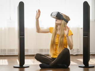 Girl wearing virtual reality goggles at home