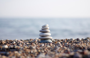 Stones tower with blurred sea background. Pyramid on the center. Zen garden. Spa set. 