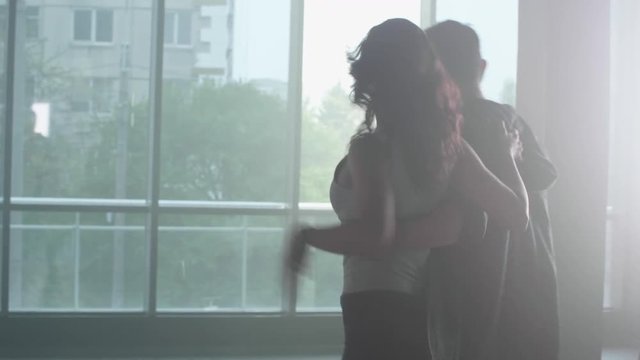 Bright led lights and urban background behing a couple dancing. Dance studio during practice hour.