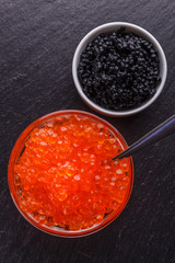 red and black caviar in a bowl on a dark stone background