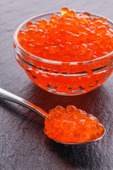 red caviar in a bowl on a dark stone background