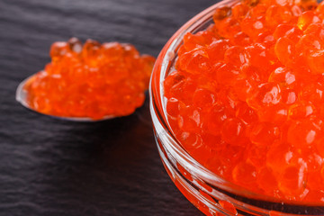 red caviar in a bowl on a dark stone background
