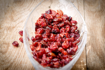 Organic cranberry, healthy dry (dried) cranberry in bowl on rustic table