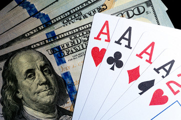 Four aces Playing Cards and Stack of 100 American Dollars Bills.