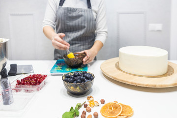 Confectioner prepares a chocolate biscuit cake decorating cream. The concept of homemade pastry, cooking cakes.