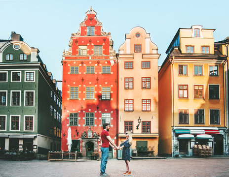 Couple in love holding hands together in Stockholm romantic date walk summer vacations lifestyle Stortorget architecture colorful houses Sweden landmarks