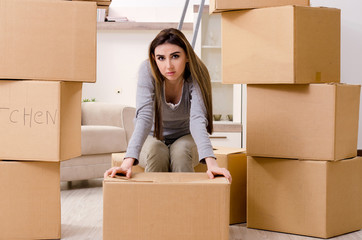 Young beautiful woman moving to new flat 