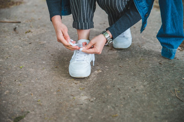 woman tie shoelaces on sneakers