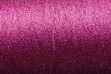 background of purple pink lurex wool on a cone