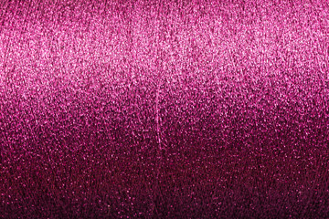 background of purple pink lurex wool on a cone