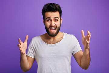 young angry bearded man expresses his negative emotions, having an argument with somebody, isolated...