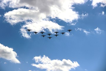 Ten planes in a blue sky with clouds on a Sunny day, selective focus