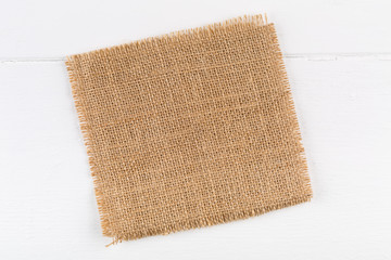 Burlap fabric cloth on white wooden kitchen table with copyspace