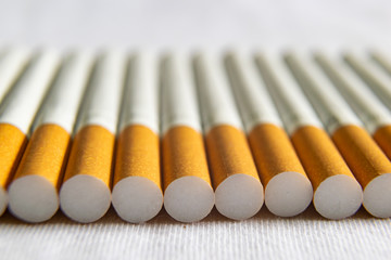 Naklejka premium Aufgereihte Zigaretten auf weißem Tuch