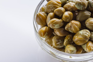 Pickled capers on a white acrylic background