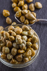 pickled capers on a dark stone background